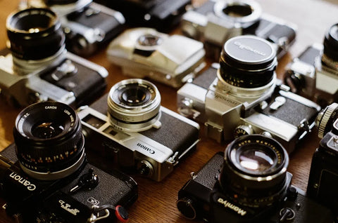 Collections appareils photo argentiques restaurés et garantis – Boutique spécialisée argentique - Canon, Mamiya, Olympus, Minolta sur la table